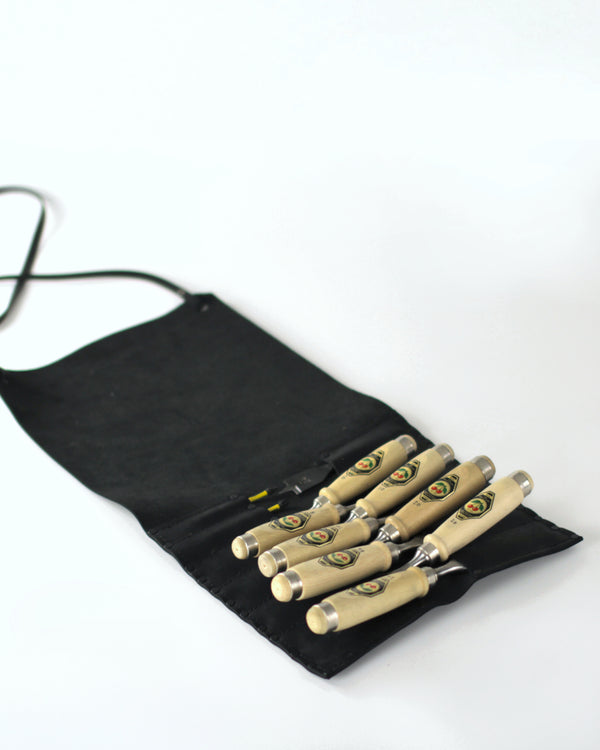 A black leather chisel roll with Two Cherries chisels against a white background. 